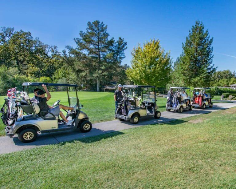 four golf carts on green grass